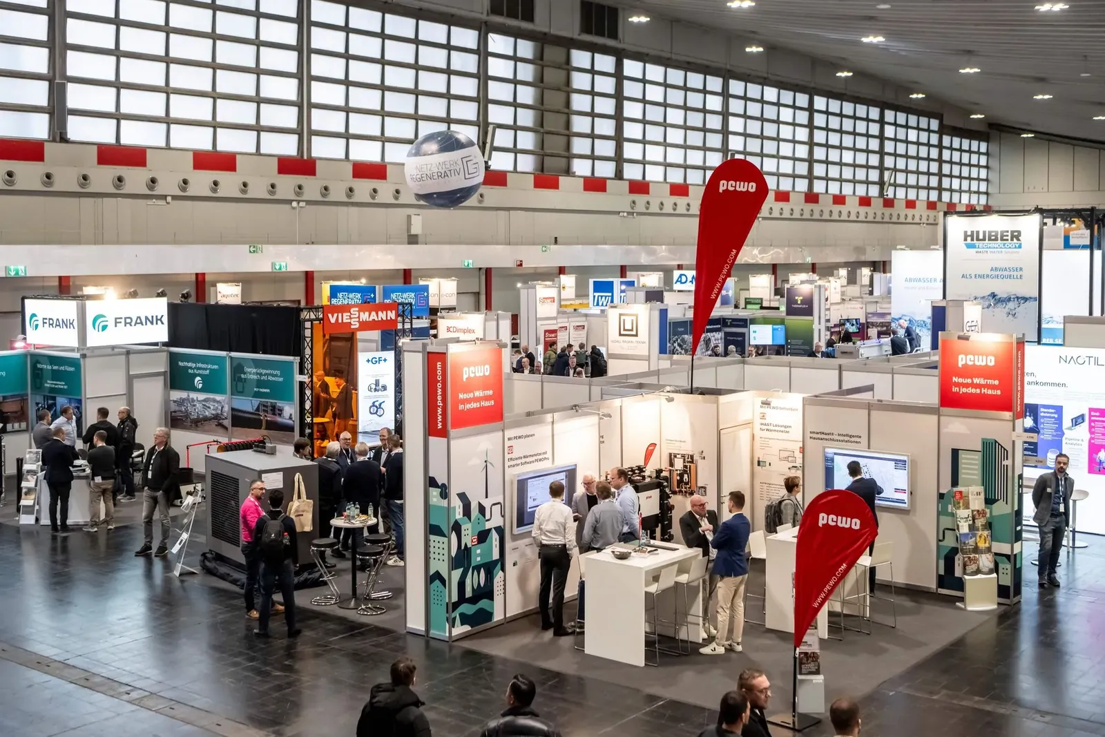 Blick in eine Messehalle der HEATEXPO mit Ausstellerständen.